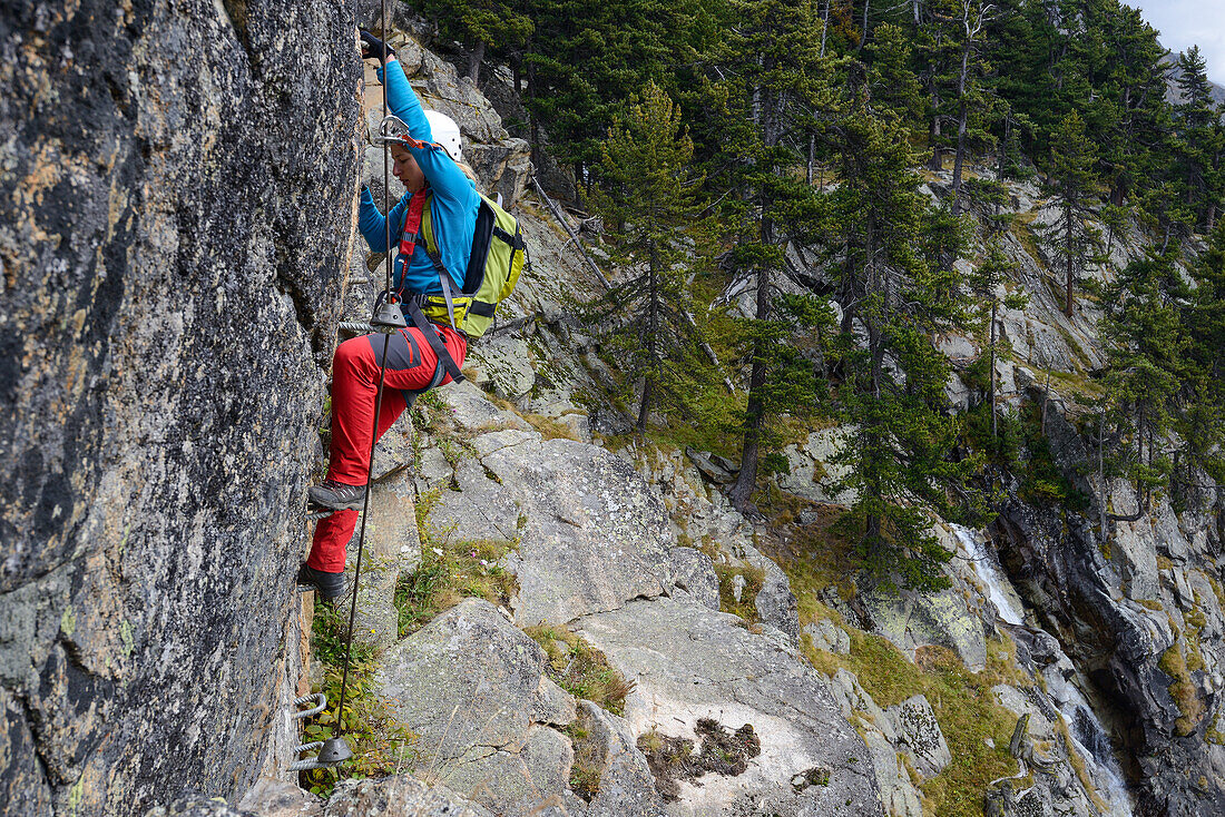 Woman climbing the via ferrata La Resgia, Engadin, Grisons, Switzerland