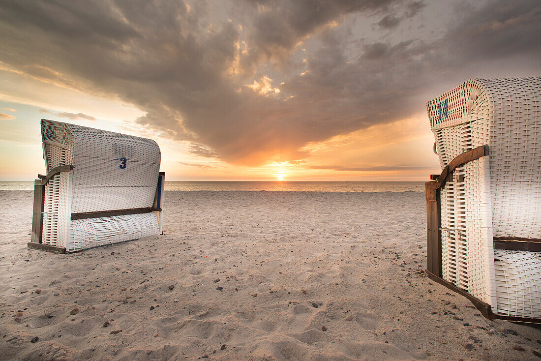 Beach chairs on the beach in Dierhagen in front of a cloudy sky and sunset, Western Pomerania Lagoon Area National Park, Dierhagen, Mecklenburg Vorpommern, Germany