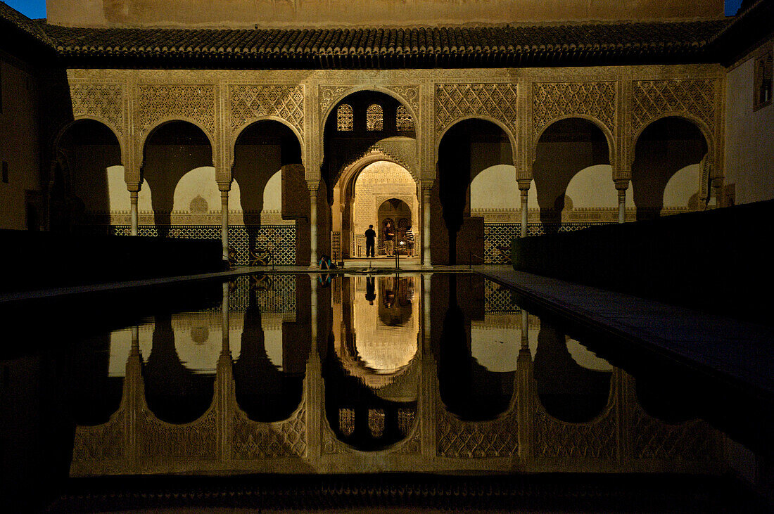 Fine Moorish wall decorations in the Nasrid palace in the Alhambra, reflections in a pool, night visit, Granada, Andalusia, Spain, Europe