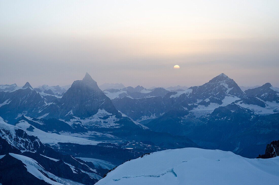 Die Sonne geht unter zwischen Matterhorn links und Dent Blanche rechts, Walliser Alpen, Kanton Wallis, Schweiz