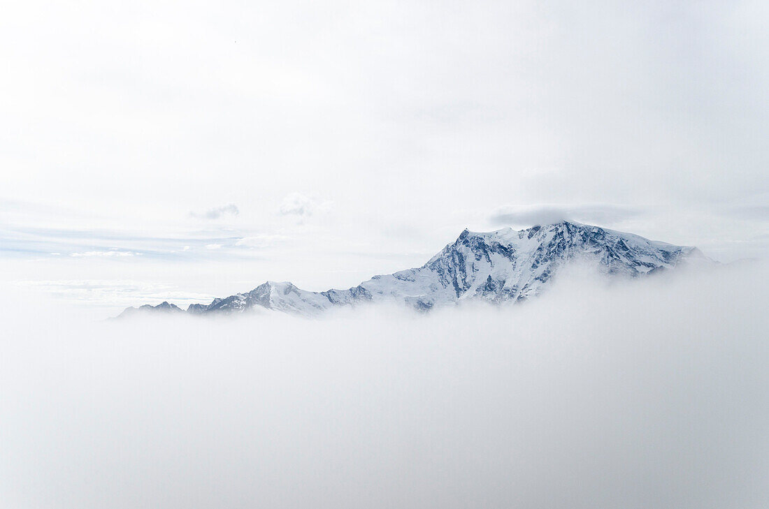 Das Massiv des Monte Rosa umgeben von Wolken, als winziger Punkt auf der Signalkuppe respektive Punte Gnifetti die Margherita Hütte, Kanton Wallis und Provinz Verbano-Cusio-Ossola, Schweiz und Italien