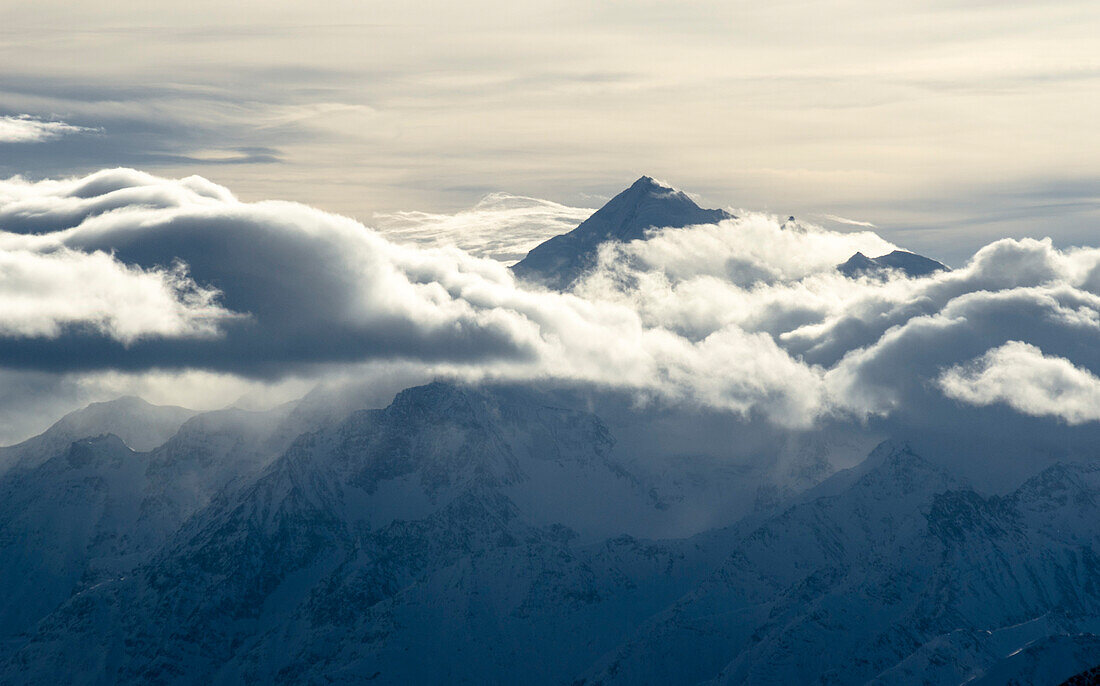 Der Gipfel des Weisshorns ragt durch eine Wolkendecke, Walliser Alpen, Kanton Wallis, Schweiz