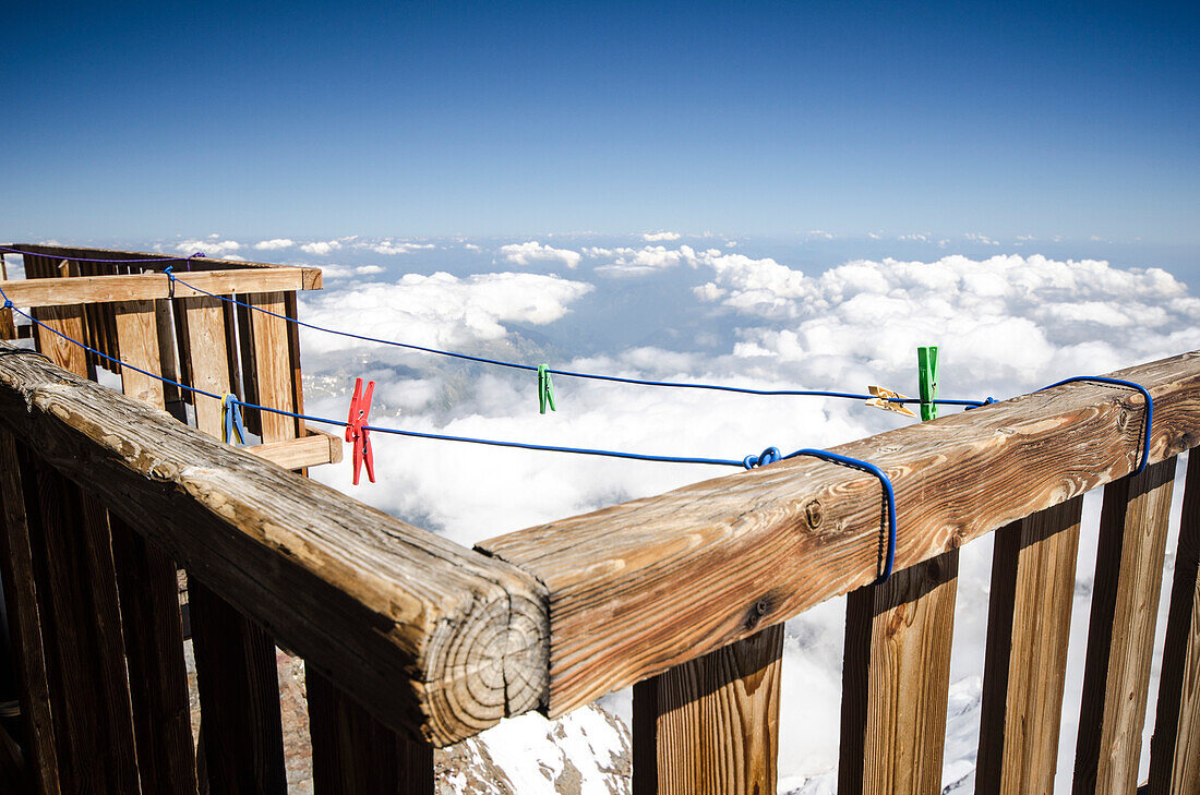 Clothes line and pegs in front of the Margherita Hut on the summit of the 4554 meter high Signalkuppe or Punta Gnifetti, highest hut in the Alps, below it a sea of clouds over northern Italy, Monte Rosa massif, Pennine Alps, Italy