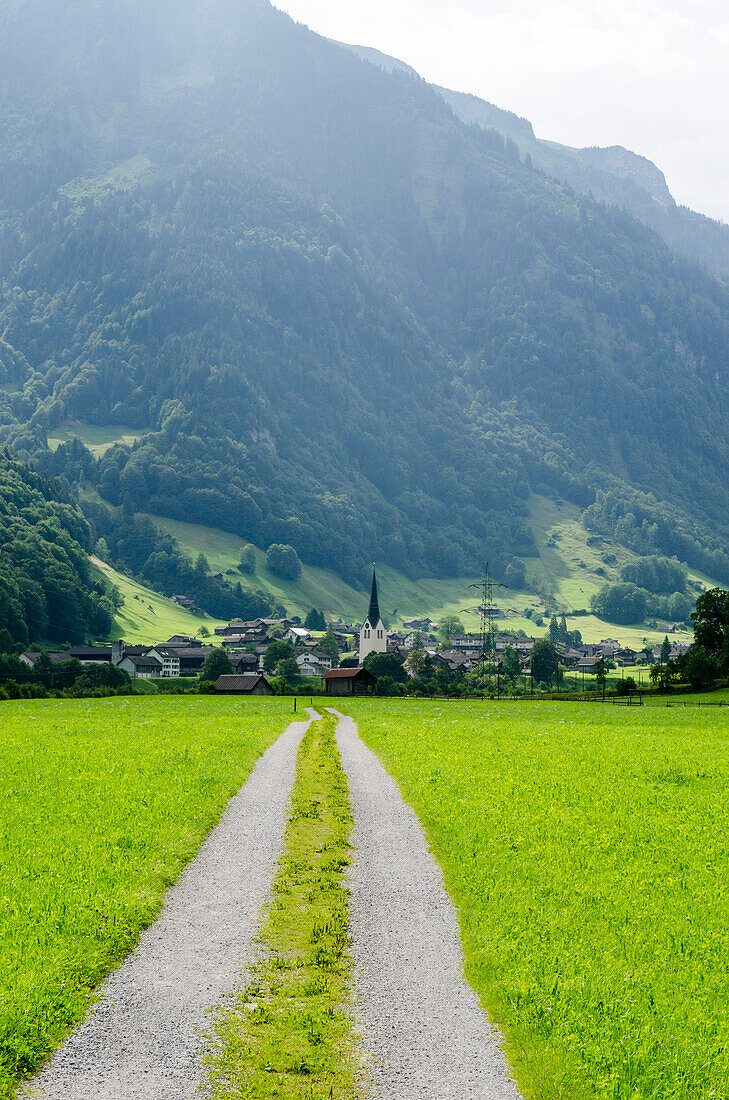 Das Dorf Matt und ein Feldweg im Sernftal, Kanton Glarus, Schweiz