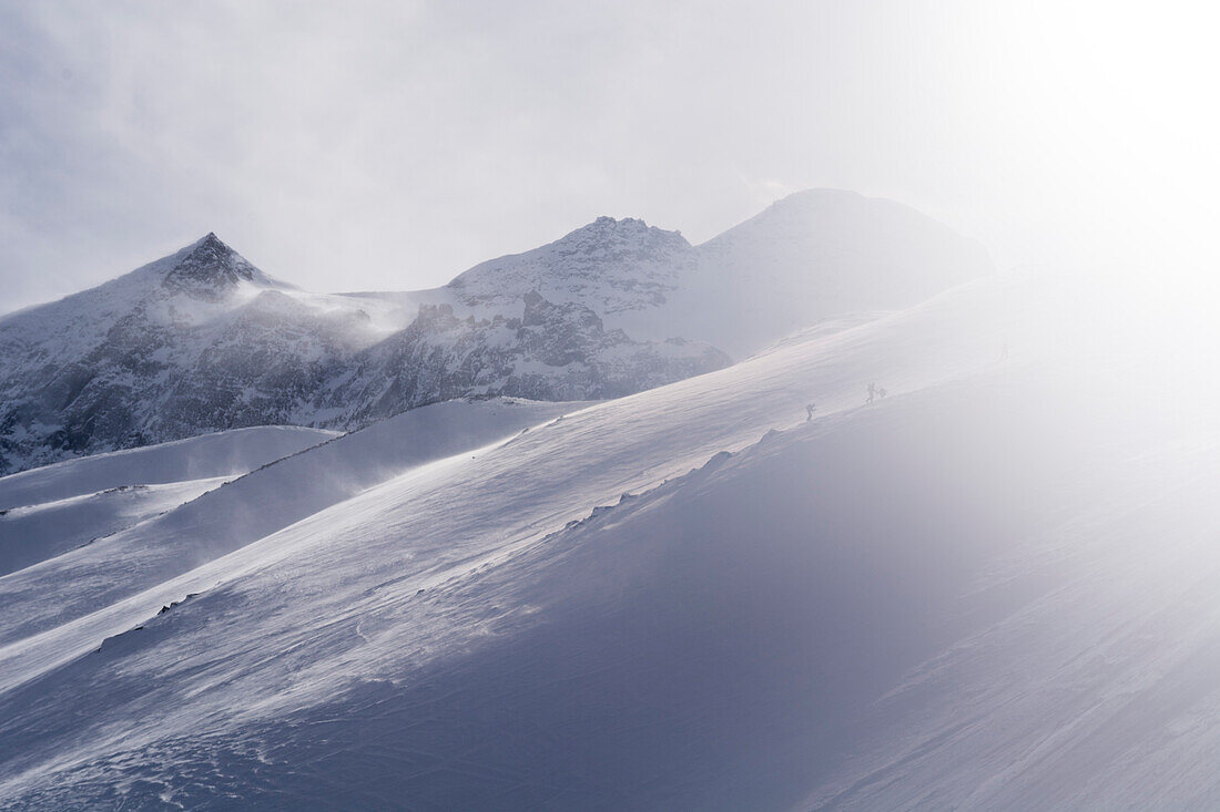 Skitourengänger steigen im Sturm auf Richtung Breithornpass, Simplongebiet, Lepontinische Alpen, Kanton Wallis, Schweiz