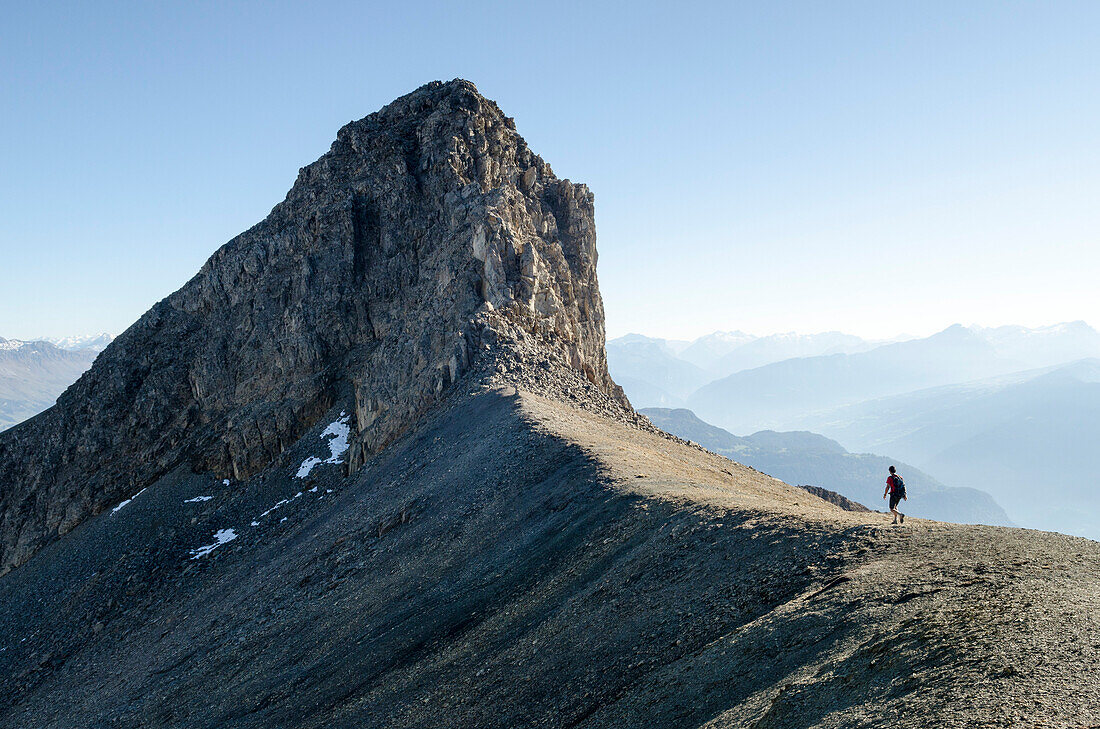 A young man hiking over trackless terrain towards the summit of Felsberger Calanda, massif of Calanda, Grison Alps, cantons of Grison and St. Gallen, Switzerland