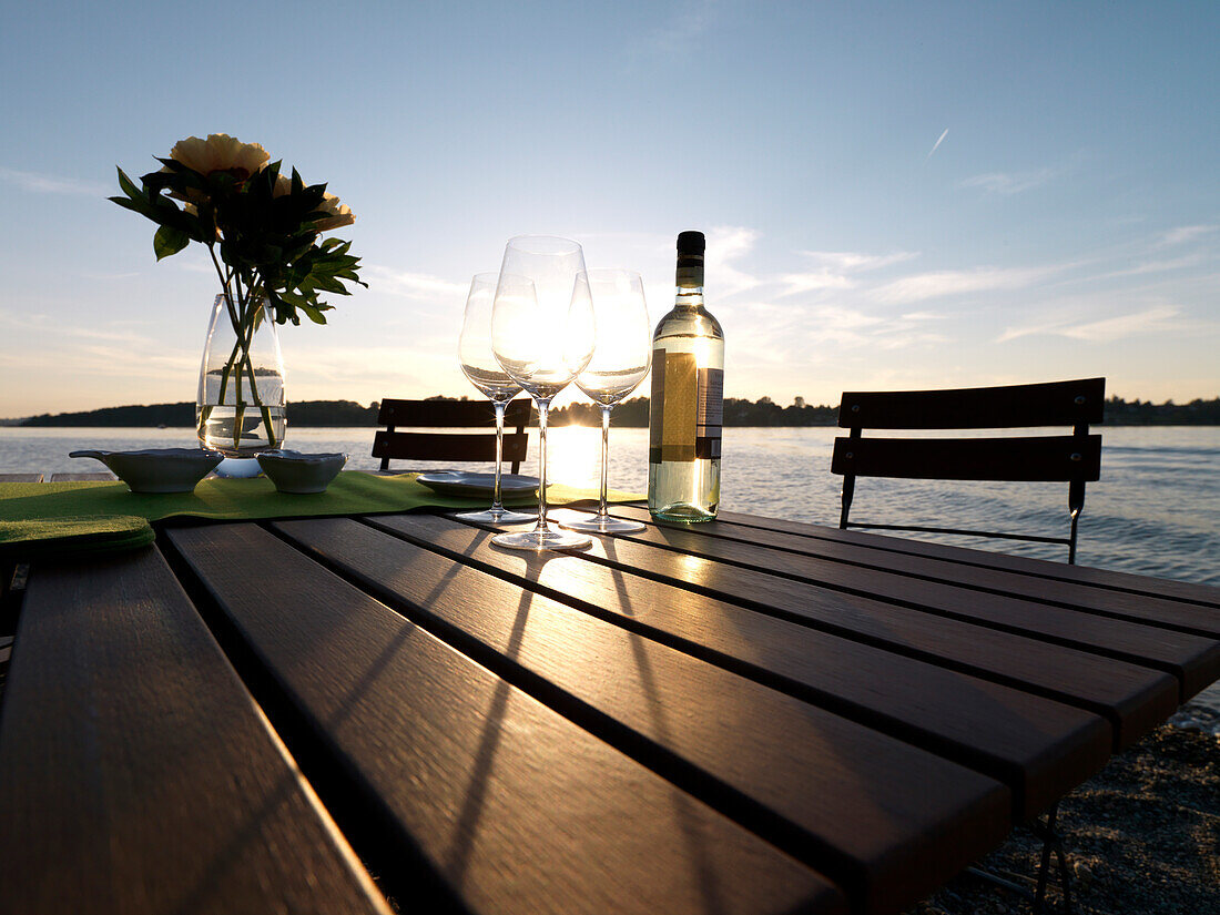 Bottle of wine and wine glasses at a table, Chiemsee, Bavaria, Germany