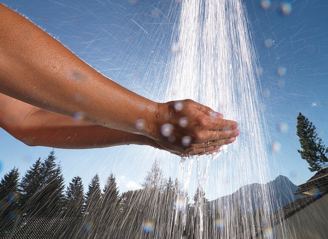 Hands under an outdoor shower, Ehrwald, Tyrol, Austria