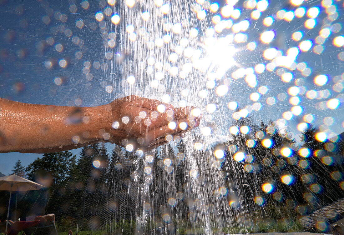 Hände unter einem Wasserstrahl, Ehrwald, Tirol, Österreich