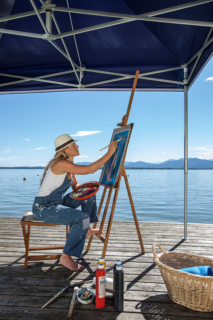 Young Woman with artist's easel painting, Fraueninsel, Chiemsee, Bavaria, Germany