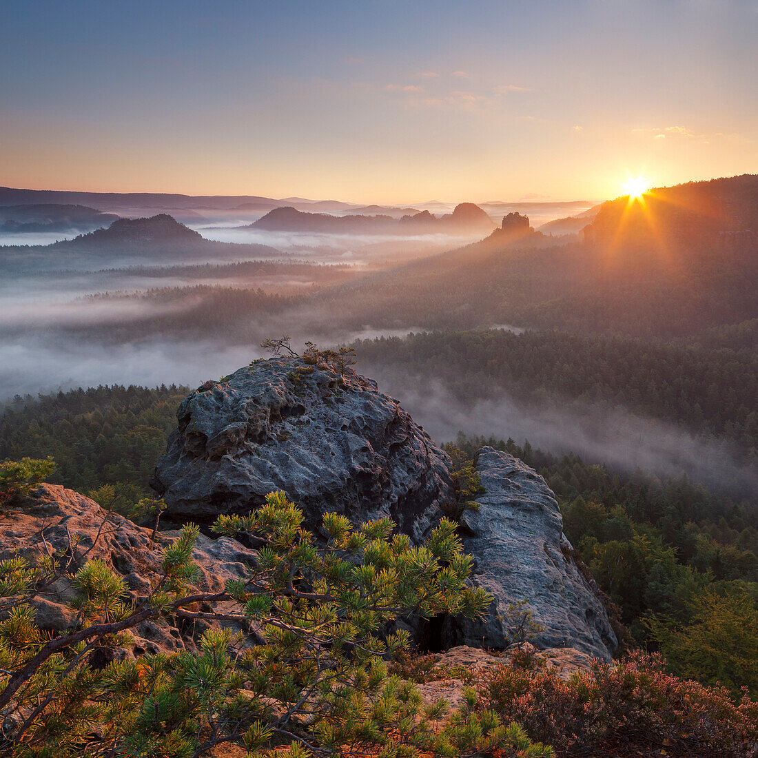 View from Gleitmannshorn over the small Zschand with fog at sunrise with rocks in foreground, Kleiner Winterberg, National Park Saxon Switzerland, Saxony, Germany