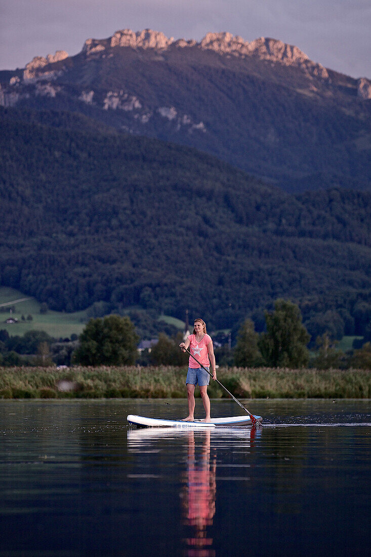 Woman stand up paddling on lake Chiemsee, Chiemgau, Bavaria, Germany