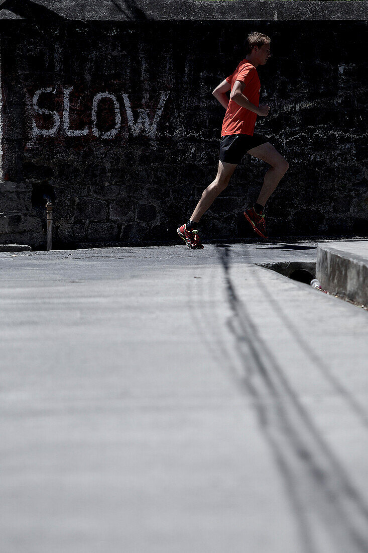 Young man running along a street, Dominica, Lesser Antilles, Caribbean