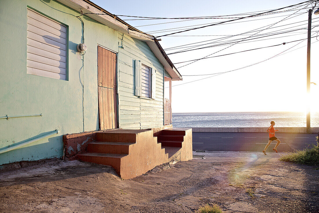 Young man running along a street, Dominica, Lesser Antilles, Caribbean