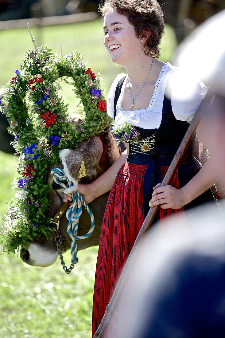 Frau im Dirndl mit einer geschmückten Kuh beim Viehscheid, Allgäu, Bayern, Deutschland