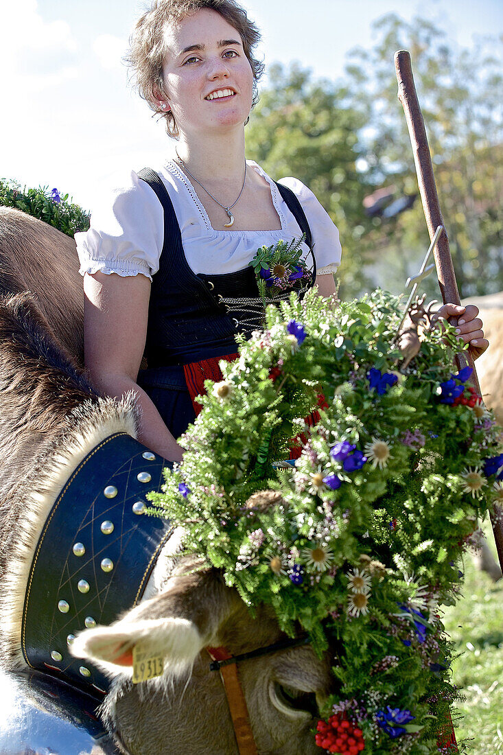 Frau im Dirndl mit einer geschmückten Kuh beim Viehscheid, Allgäu, Bayern, Deutschland