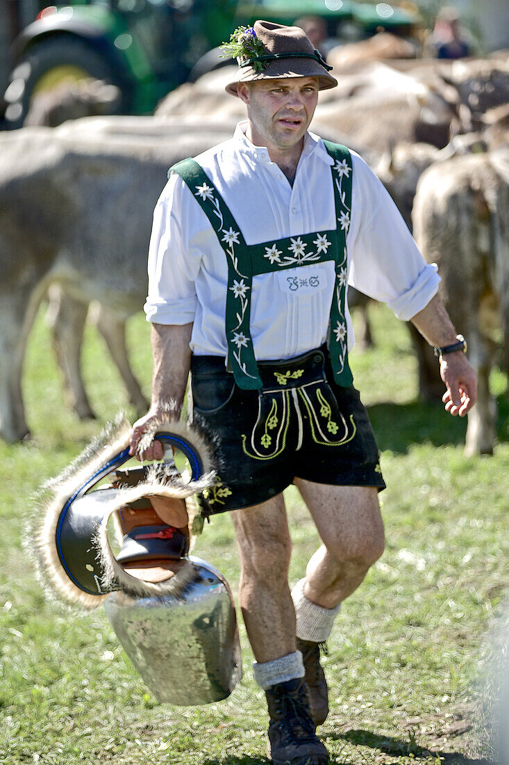 Man wearing traditional clothes carrying a cow bell, Viehscheid, Allgau, Bavaria, Germany