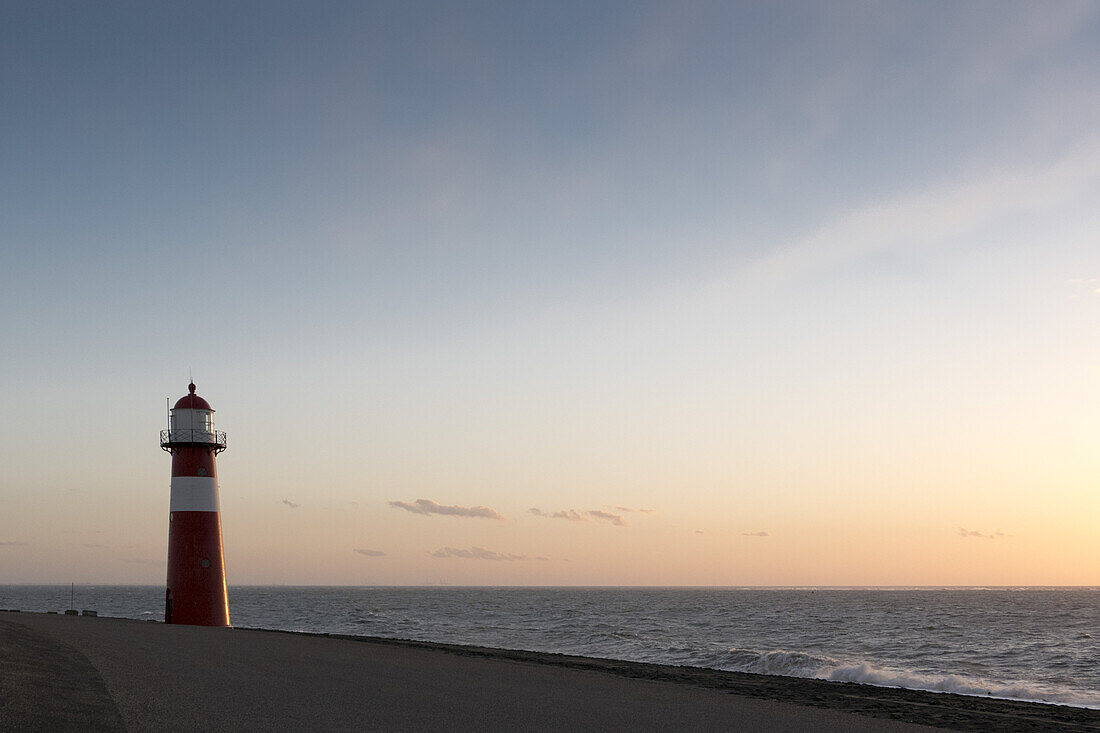Leuchtturm am Meer bei Sonnenuntergang, Westkapelle bei Domburg, Nordsee-Küste, Provinz Seeland, Niederlande