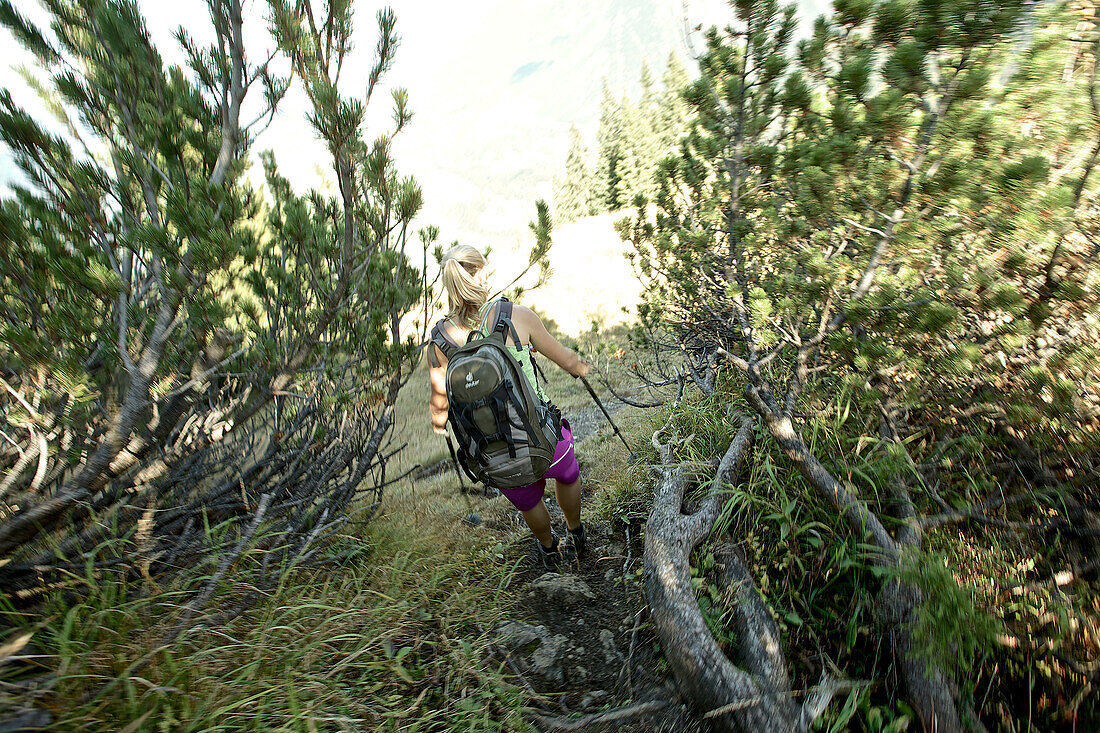 Young woman hiking in the mountains on a sunny day, Oberstdorf, Bavaria, Germany