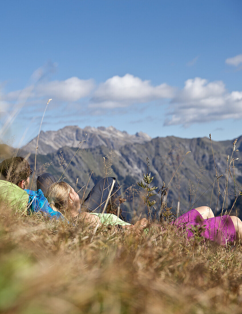 Couple machen eine Pause vom Wandern an einem sonnigen Tag, Oberstdorf, Bayern, Deutschland