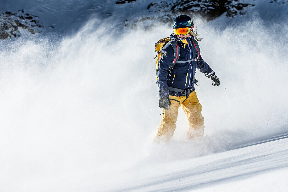 Junge Snowboarderin fährt im Tiefschnee in den Bergen, Pitztal, Tirol, Österreich