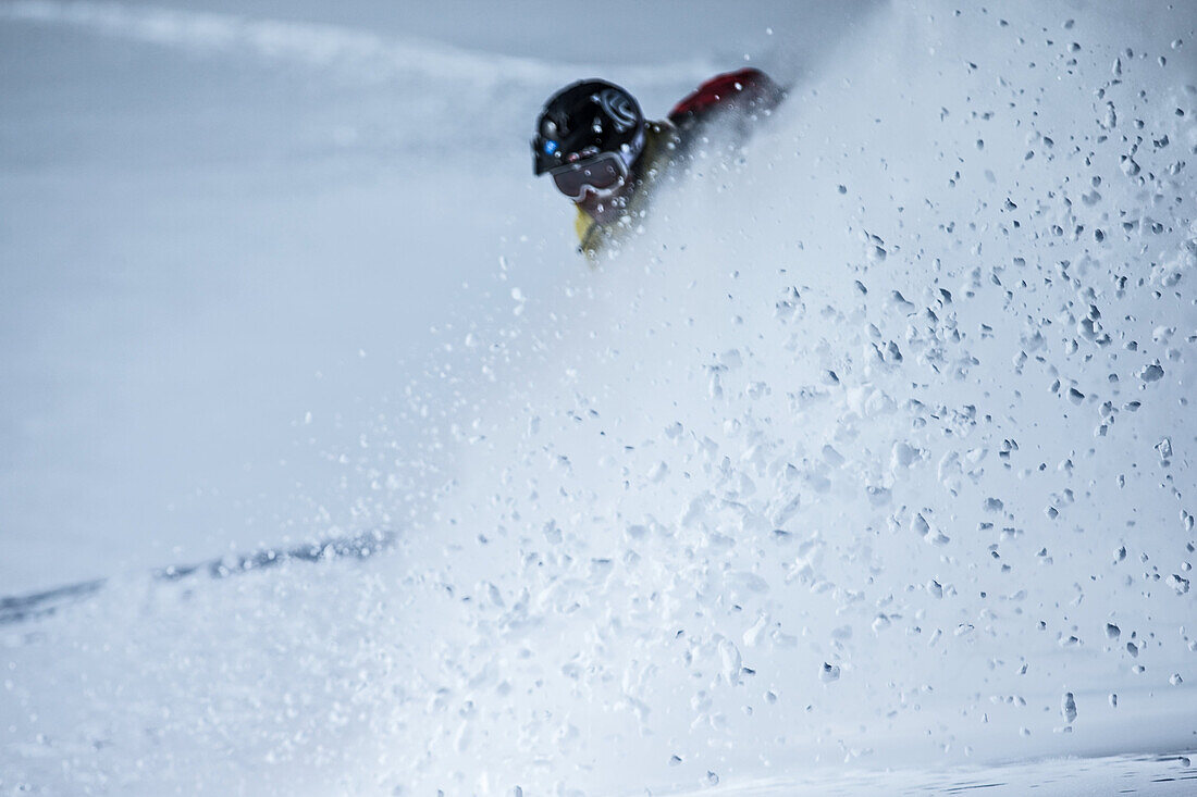 Junger Snowboarder fährt durch den Tiefschnee in den Bergen, Pitztal, Tirol, Österreich
