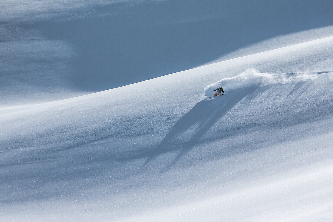 Young female freeskier riding through deep powder snow in the mountains, Pitztal, Tyrol, Austria