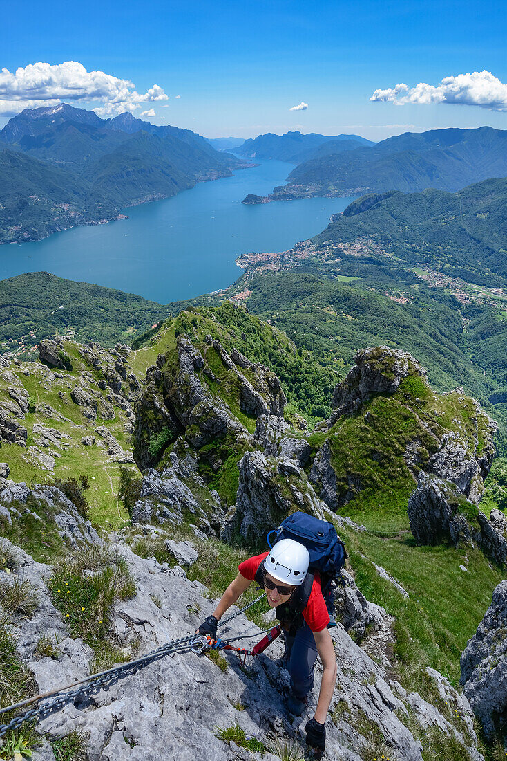 Frau im Klettersteig Via Ferrata del Centenario vor Menaggio rechten Ufer des Comer Sees und Grigna Settentrionale (2408 m) darüber, Italien