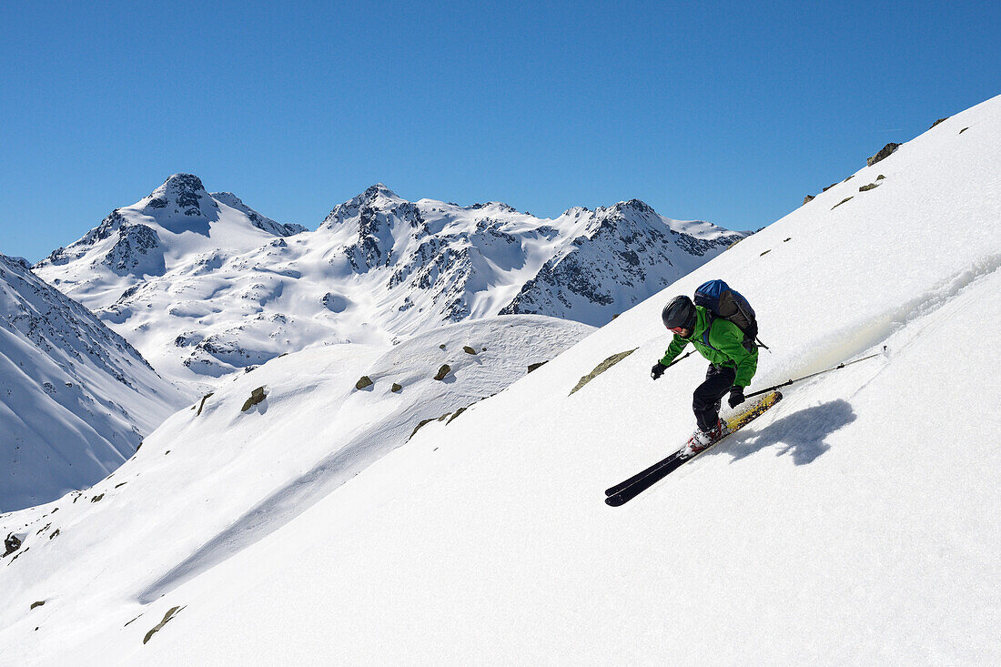 Mann fährt Ski in feinstem Firn, darüber das Bocktenhorn (3044 m), Graubünden, Schweiz, Europa