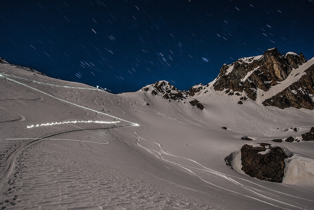 Ski-tourers in the light of the full-moon (ascent- and descent-tracks) close to the Grialetsch hut, Grisons, Switzerland, Europe