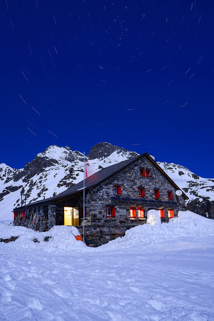 Full-moon over the Grialetsch hut (2542 m) with Piz Radoent (3065 m) and a carousel of stars above it, Grisons, Switzerland, Europe