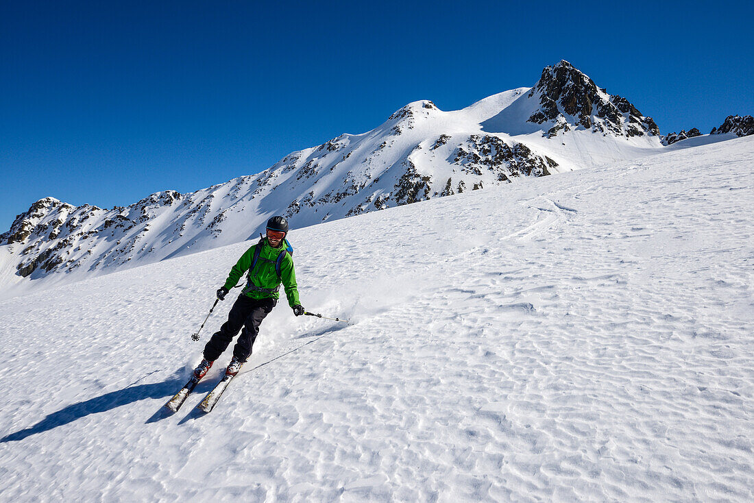 Skifahrer auf dem unverspurten Grialetsch-Gletscher (Vadret da Grialetsch) mit Piz Sarsura (3178 m) darüber, Engadin, Schweiz, Europa