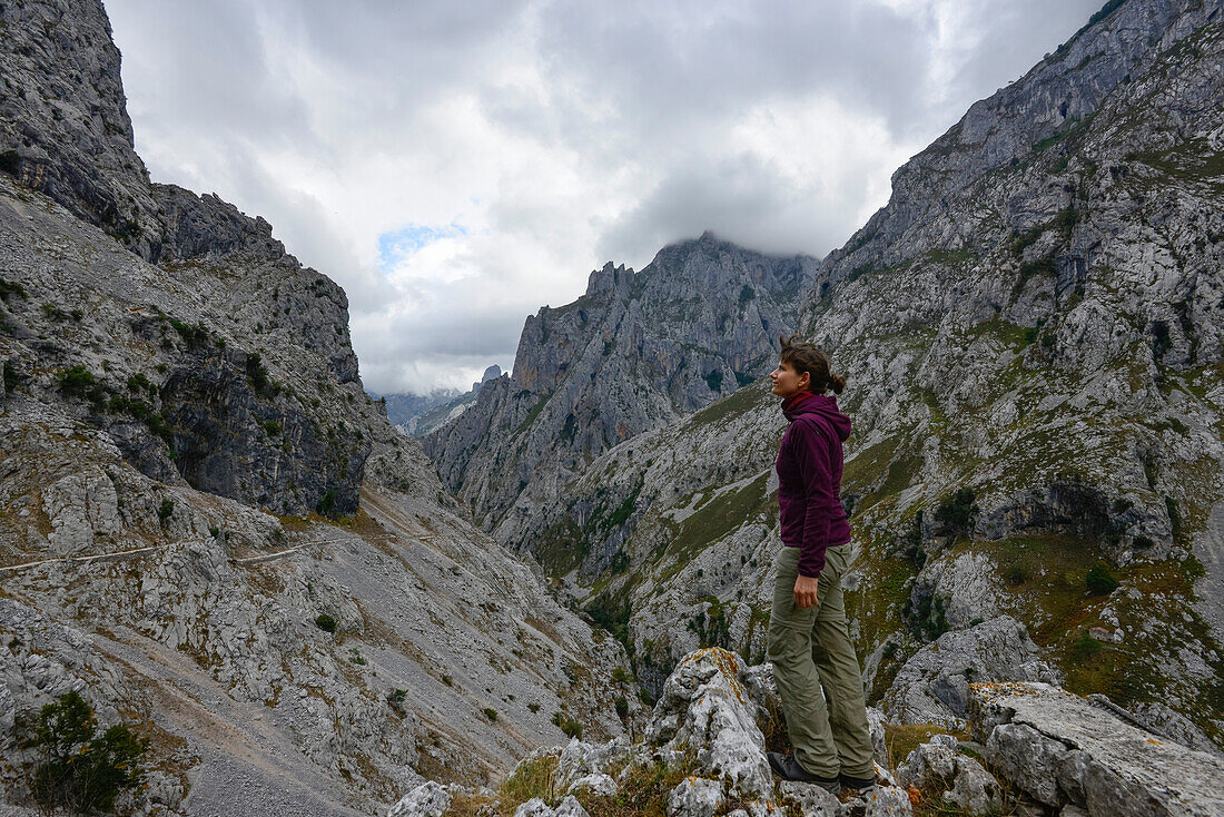 young woman at hiking trail Ruta del Cares is connecting Bulnes and Poncebos, Cabrales, mountains of Parque Nacional de los Picos de Europa, Asturias, Spain