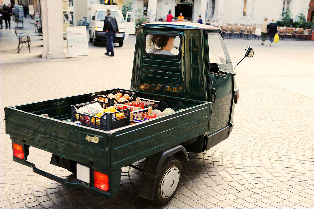 Pickup loaded with vegetables passing the old town, Arco, Trentino, Italy