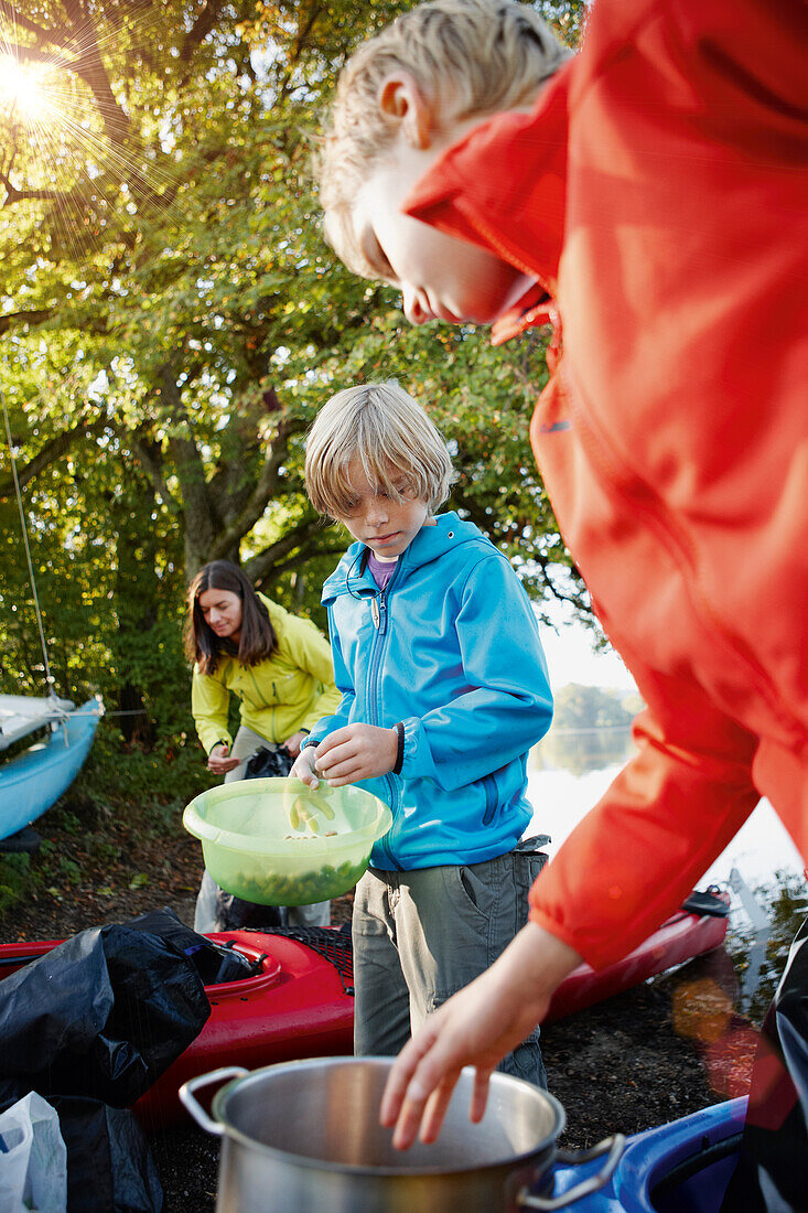 Zwei Jungen kochen am Seeufer, Staffelsee, Seehausen, Oberbayern, Bayern, Deutschland