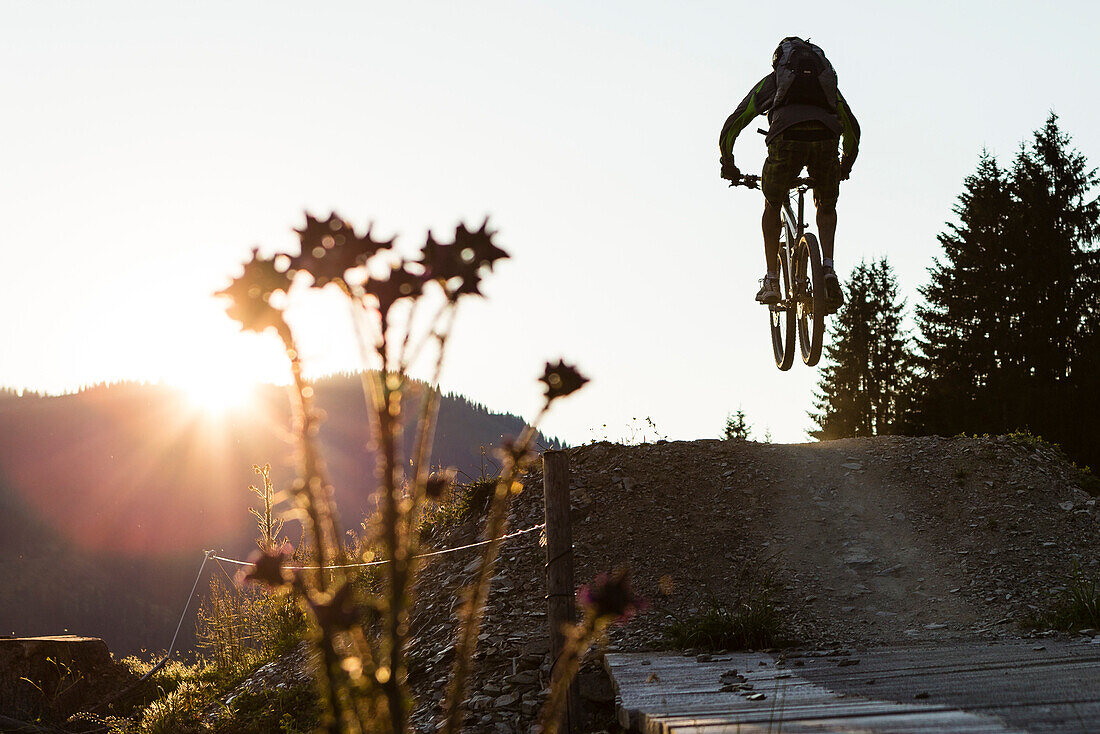 Mountainbiker bei Sprung im Bikepark Saalbach-Hinterglemm, Salzburg, Österreich