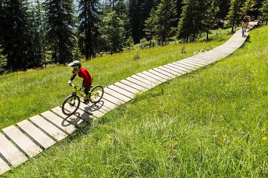 mountain biker on a wooden path in Bikepark Saalbach-Hinterglemm, Salzburg, Austria