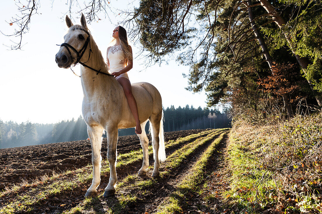 girl in a white dress riding her horse, Freising, Bavaria, Germany
