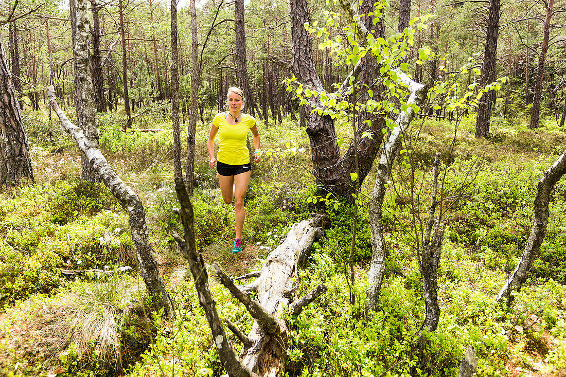 young woman running in a moorland forest, Berg at Lake Starnberg, Upper Bavaria, Germany