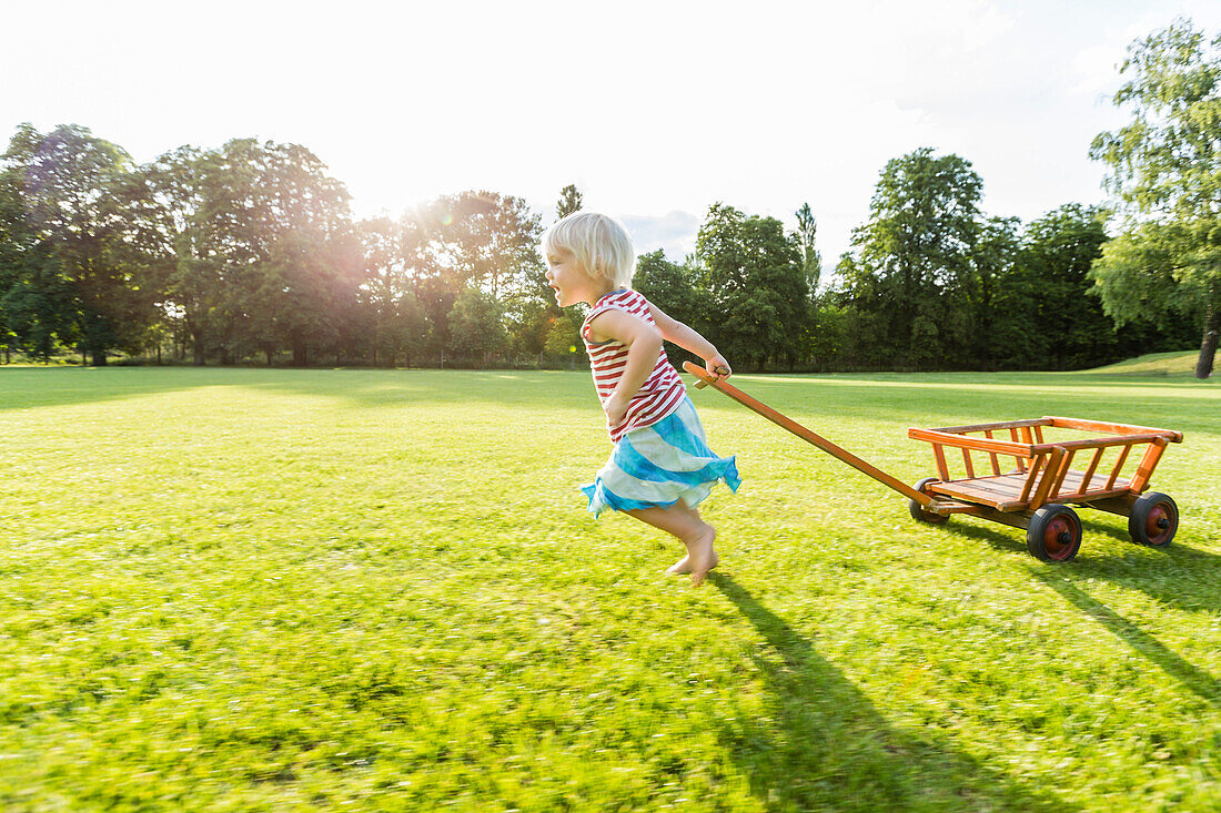 two-year-old girl pulling wagon, Speyer, Rheinland-Pfalz, Germany