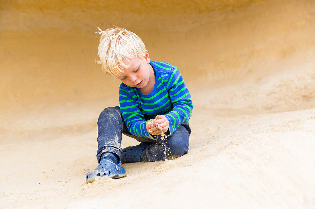 4 years old boy playing with sand on the beach of Portals Vells, MR, near Magaluf, Majorca, Balearic Islands, Spain, Europe