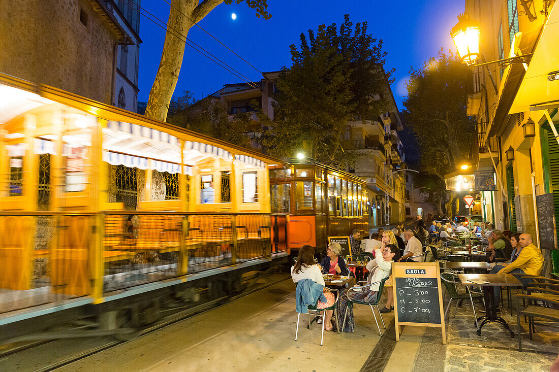 historical tram driving between Port de Soller and Palma de Mallorca in the evening, guests in restaurants, Serra de Tramuntana, Soller, Majorca, Balearic Islands, Spain, Europe