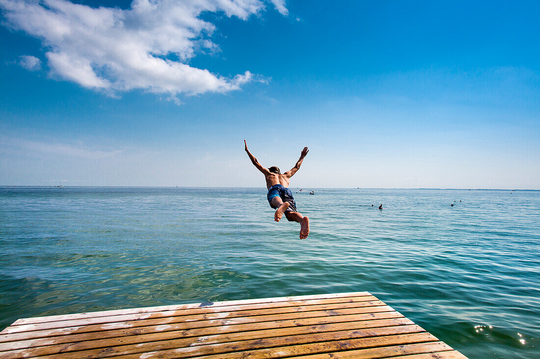 Boy diving from a pier, South beach, Burgtiefe, Fehmarn island, Baltic Coast, Schleswig-Holstein, Germany