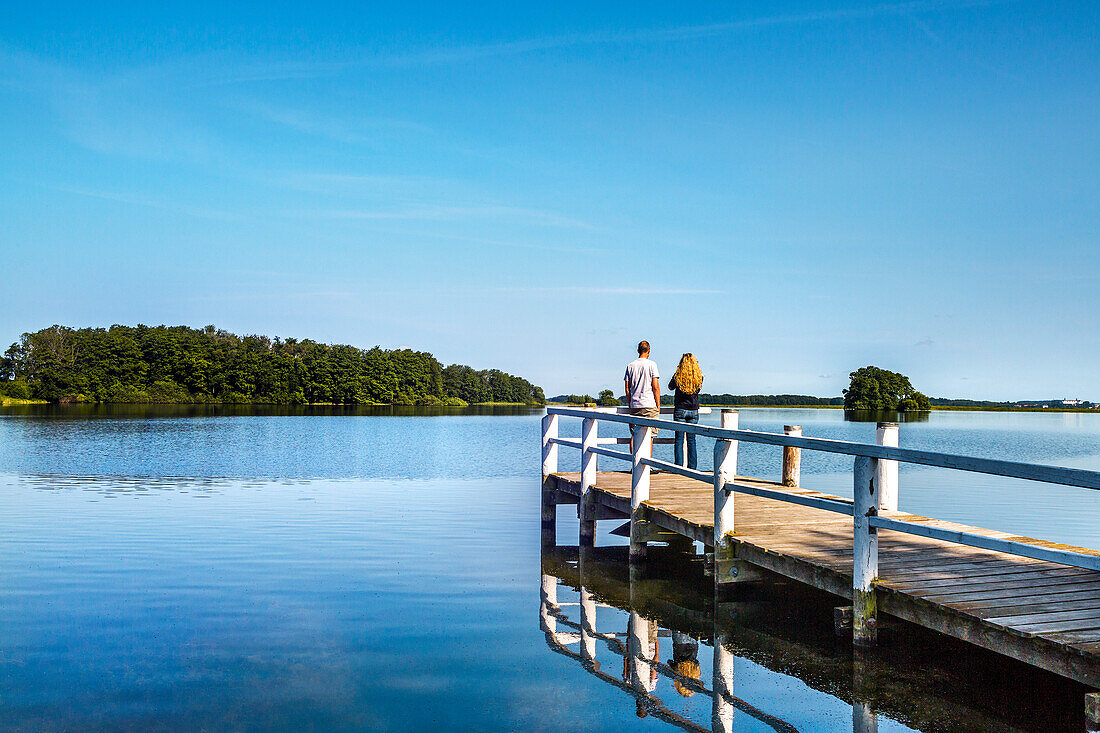 Couple on a pier at lake Ploen, Bosau, Holstein Switzerland, Ostholstein, Schleswig-Holstein, Germany