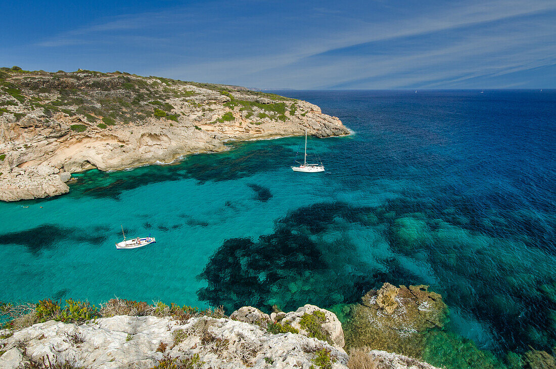 Eine Segelyacht und ein Fischerboot ankern in einer einsamen Bucht mit türkisblauem Wasser, Mallorca, Balearen, Spanien, Europa