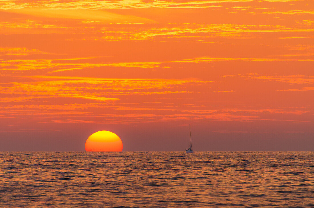 Eine Segelyacht im Sonnenuntergang an der Nordküste von Mallorca, Balearen, Spanien, Europa