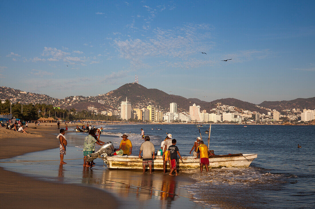 Fischer entladen ihren Fang von einem Fischerboot am Strand Playa Las Hamacas Acapulco, Guerrero, Mexiko, Mittelamerika