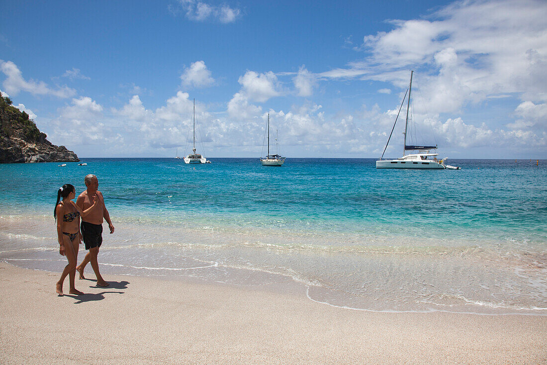 Junges Paar am Strand Governor's Beach mit Segelbooten, Gustavia, St. Barthelemy (St. Barth), Karibik