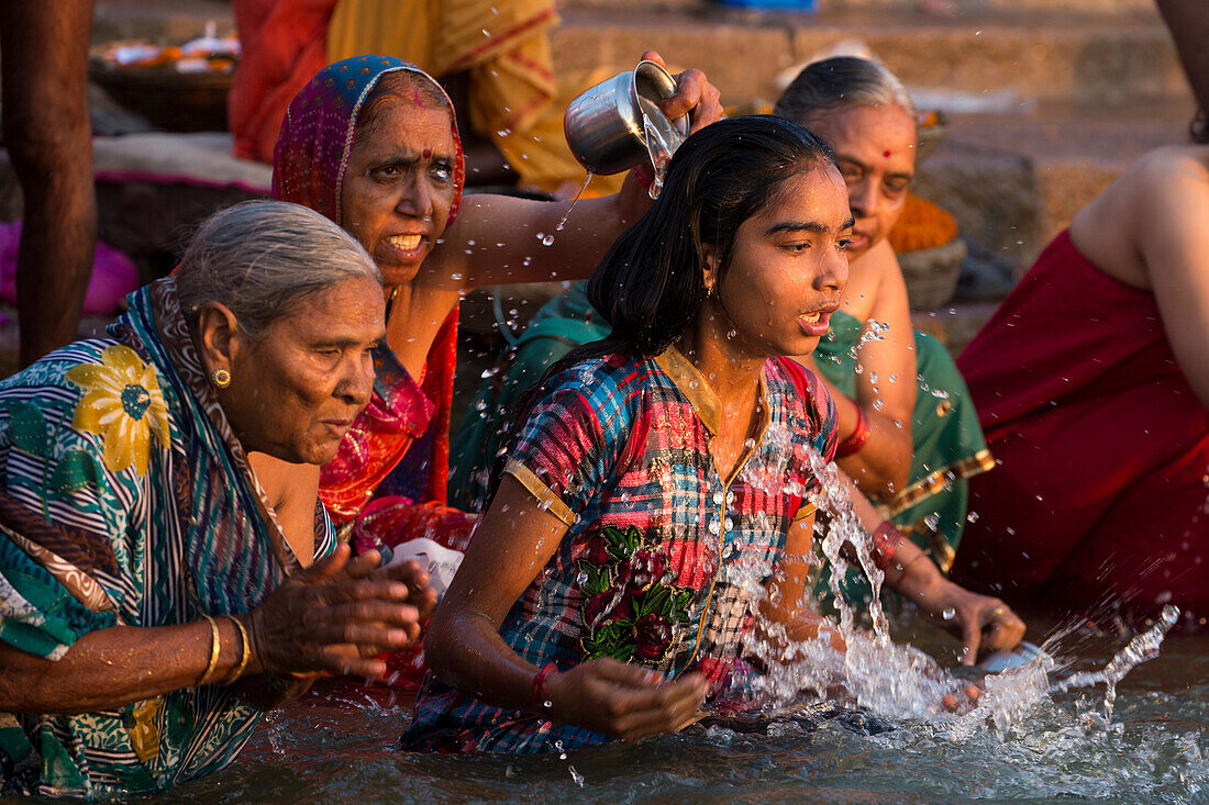 Women wash themselves and pray in water of Ganges river at Dasaswamedh Ghat, Varanasi, Uttar Pradesh, India