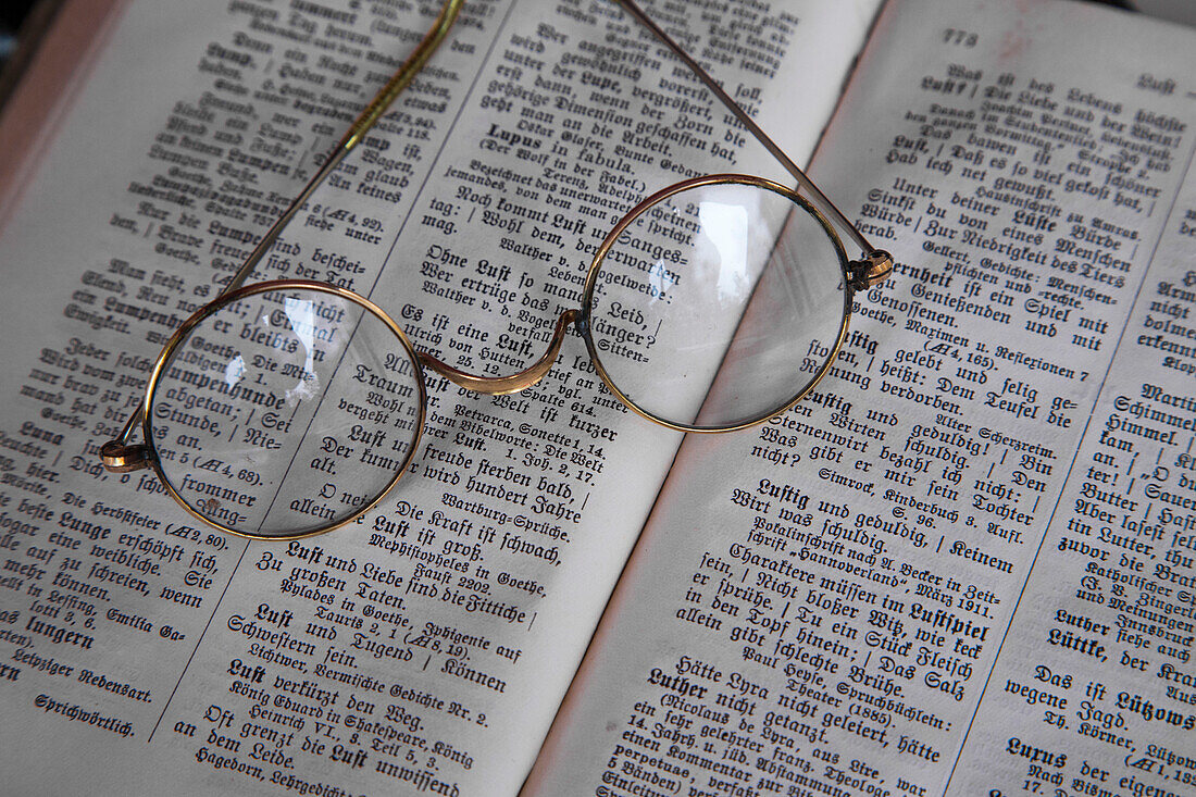 Old reading glasses on book with old German language type, Haunetal, Hesse, Germany